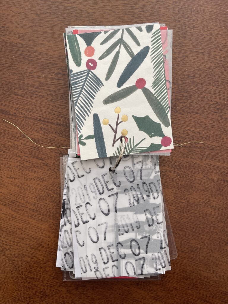 A spread from the album. The top page is a piece of patterned paper. The bottom page is a piece of vellum stamped repeatedly with the date. Beneath the vellum is a black-and-white photo from that year's visit. 