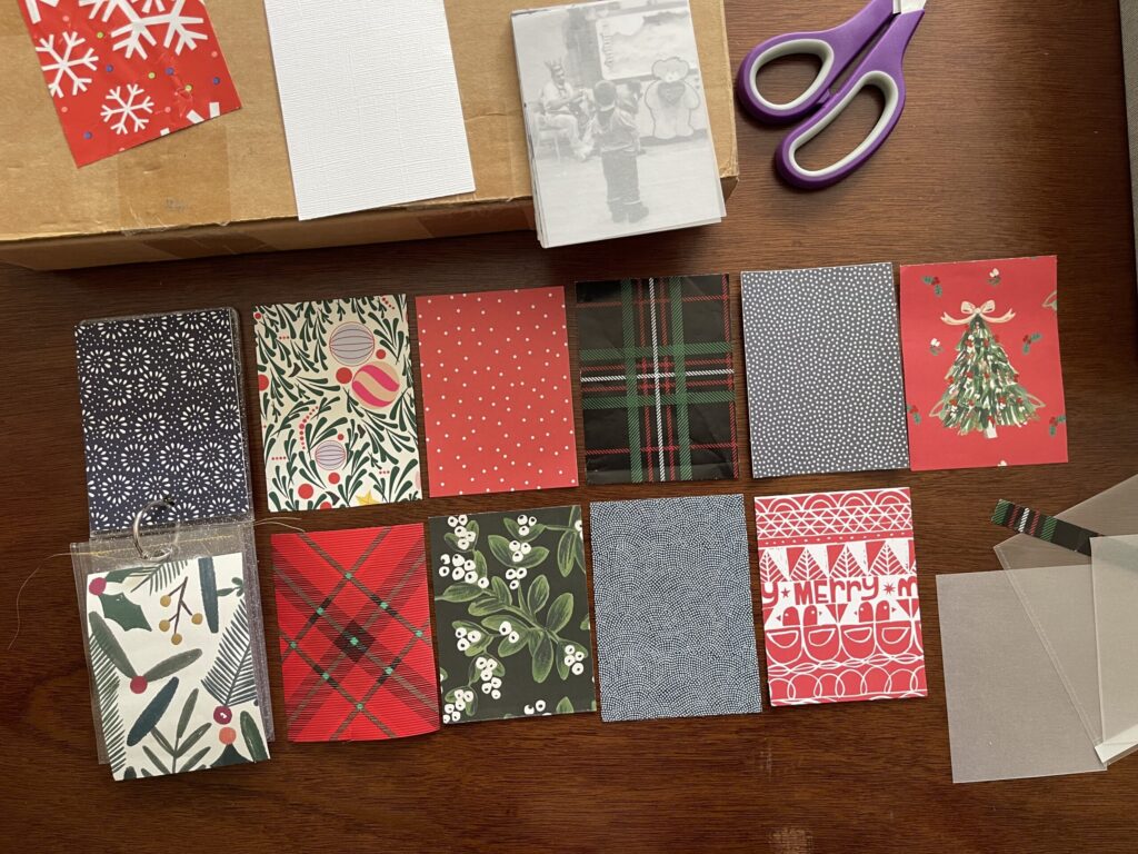 Various holiday-themed papers cut down to 3 inches by 4 inches and arranged in two rows. 