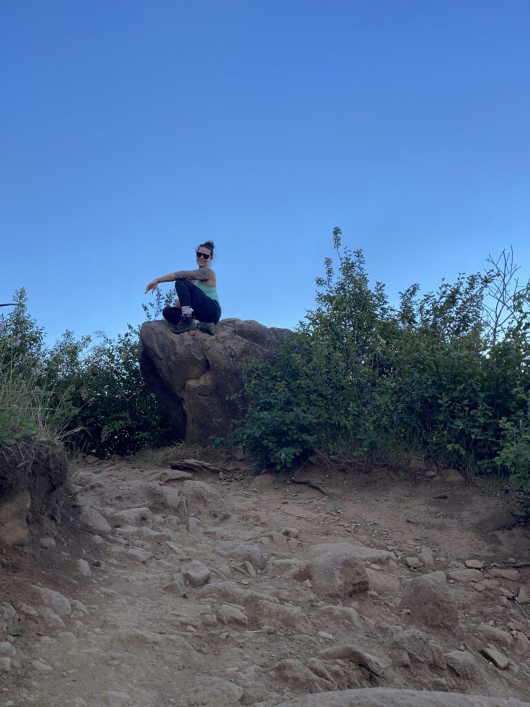 A photo of me on a boulder in July 2025, with the Columbia River in the background.