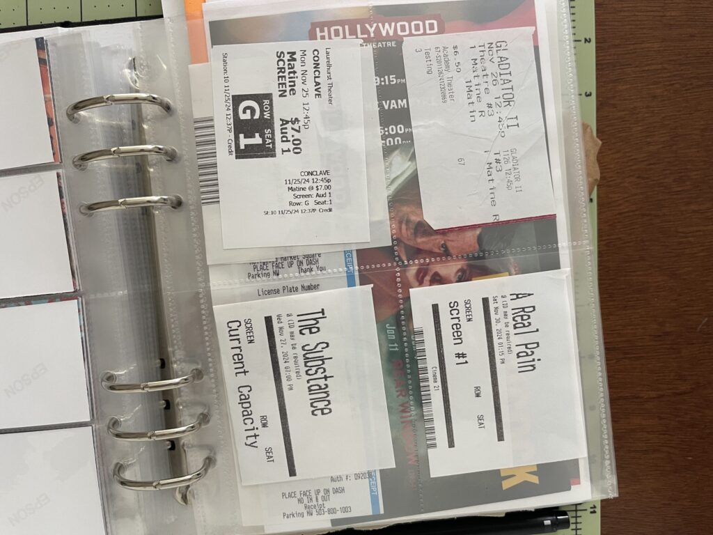 A 6-inch by 8-inch page protector divided into four 3-inch by 4-inch pockets. In each pocket, a ticket stub from a movie I saw in a theater in 2024. 