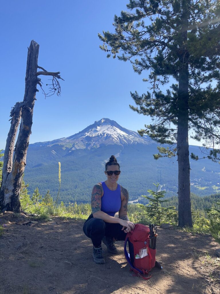 Me, crouched down low at the summit of Tom Dick and Harry, Mount Hood in the background. 