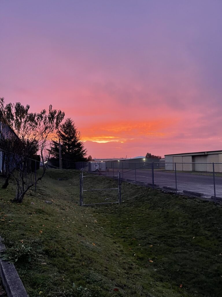 Fiery orange and pink clouds blocking the sunrise over Mount Hood. 