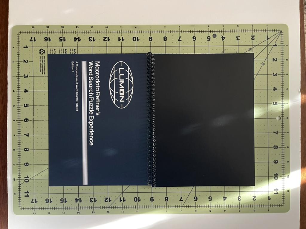 The completed, bound booklet laid face up on a cutting mat, so that the front and back covers are both visible.