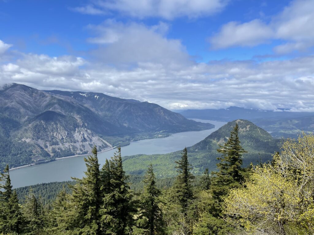 View of the Columbia River Gorge from the summit of Dog Mountain on a partly cloudy day in May 2022. 