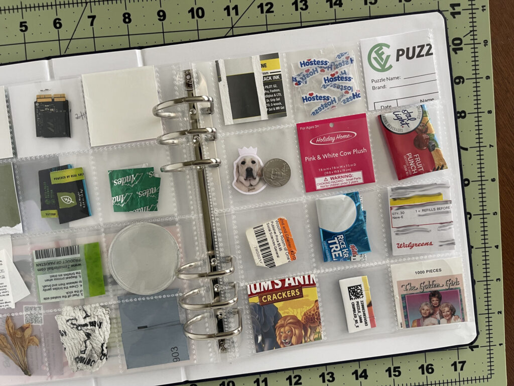 A 6-inch by 8-inch page protector divided into 12 two-inch by two-inch pockets. Each pocket hold a piece of ephemera from my life in February 2026, as enumerated in the bulleted lists in the body of the post.