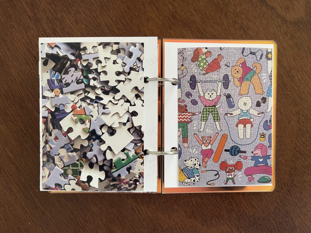 Spread #5. The left-hand page is a photo of the puzzle's unpuzzled pieces. The right-hand page is a photo of the completed puzzle of illustrations of various breeds of dogs performing different exercises like jumping rope, stretching, weightlifting, etc. 