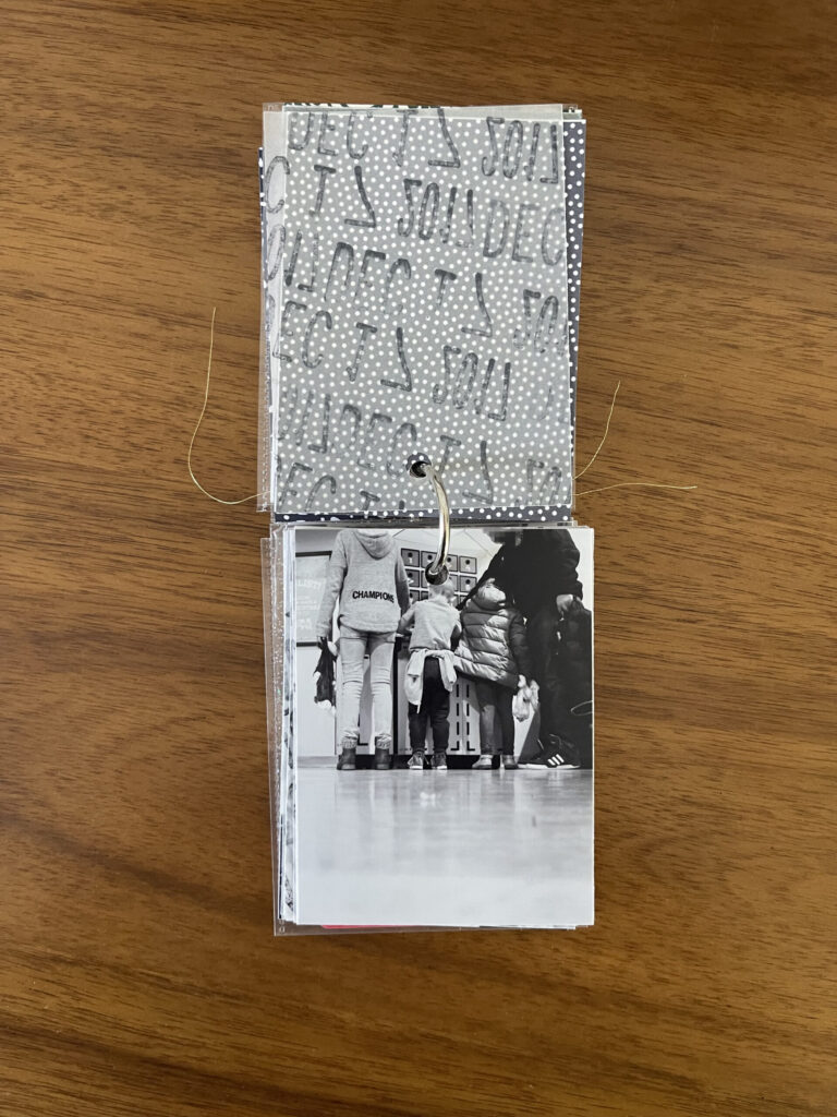2017: the vellum page stamped with the date is flipped over to reveal and black-and-white photo of three kids and one dad in line to have their stuffed animals stuffed by the Build-A-Bear employee. 