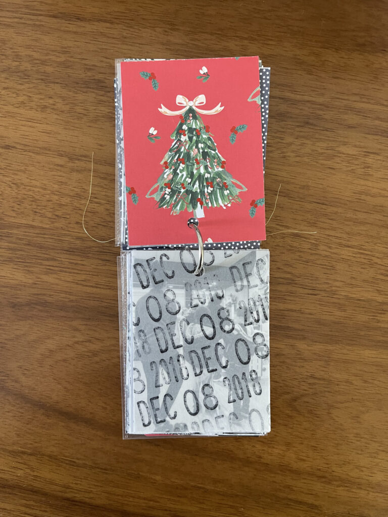 2018. The top page is a piece of patterned paper. The bottom page is a piece of vellum stamped repeatedly with the date. Beneath the vellum is a black-and-white photo from that year's visit. 