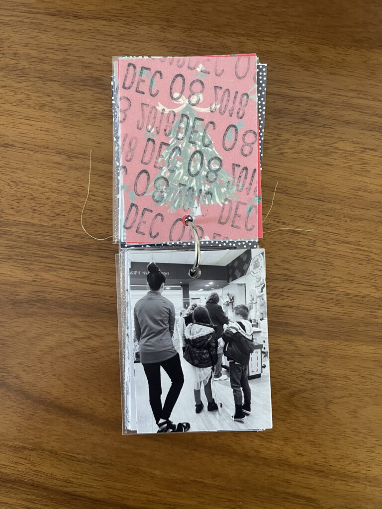 2018: the vellum page stamped with the date is flipped over to reveal and black-and-white photo of four kids in line for me to pay for their stuffed animals.