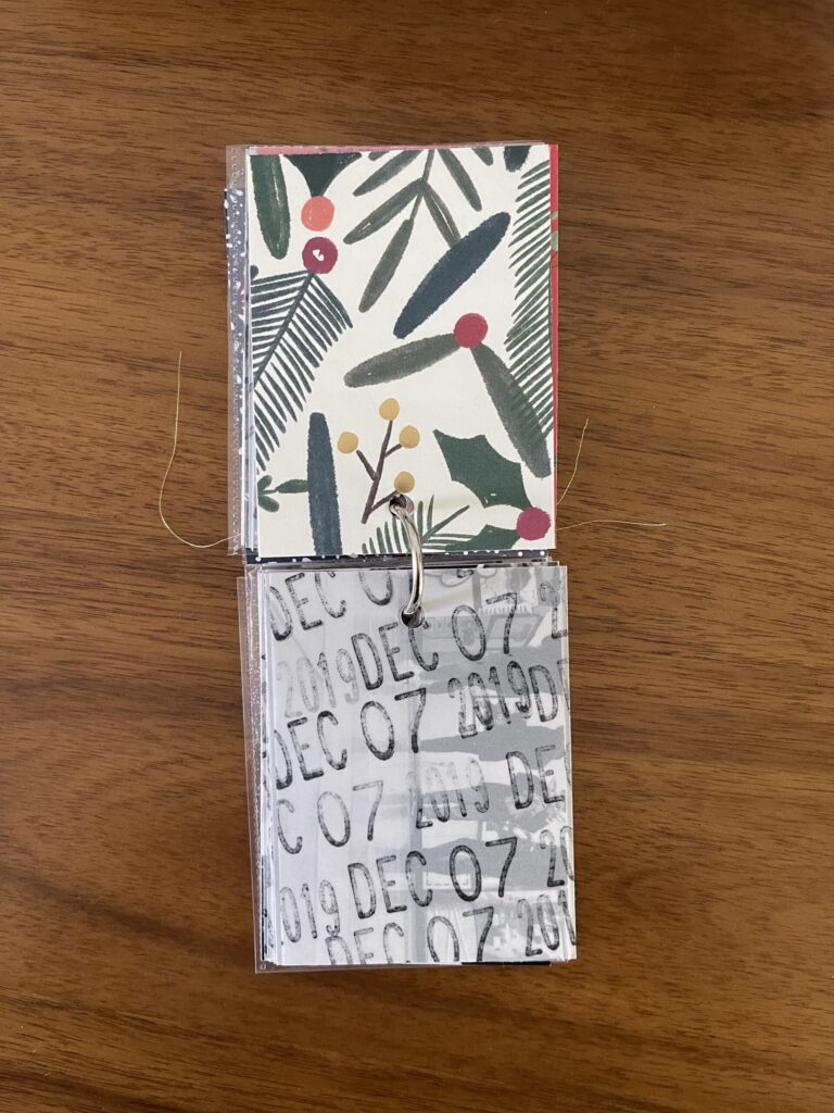 2019. The top page is a piece of patterned paper. The bottom page is a piece of vellum stamped repeatedly with the date. Beneath the vellum is a black-and-white photo from that year's visit. 