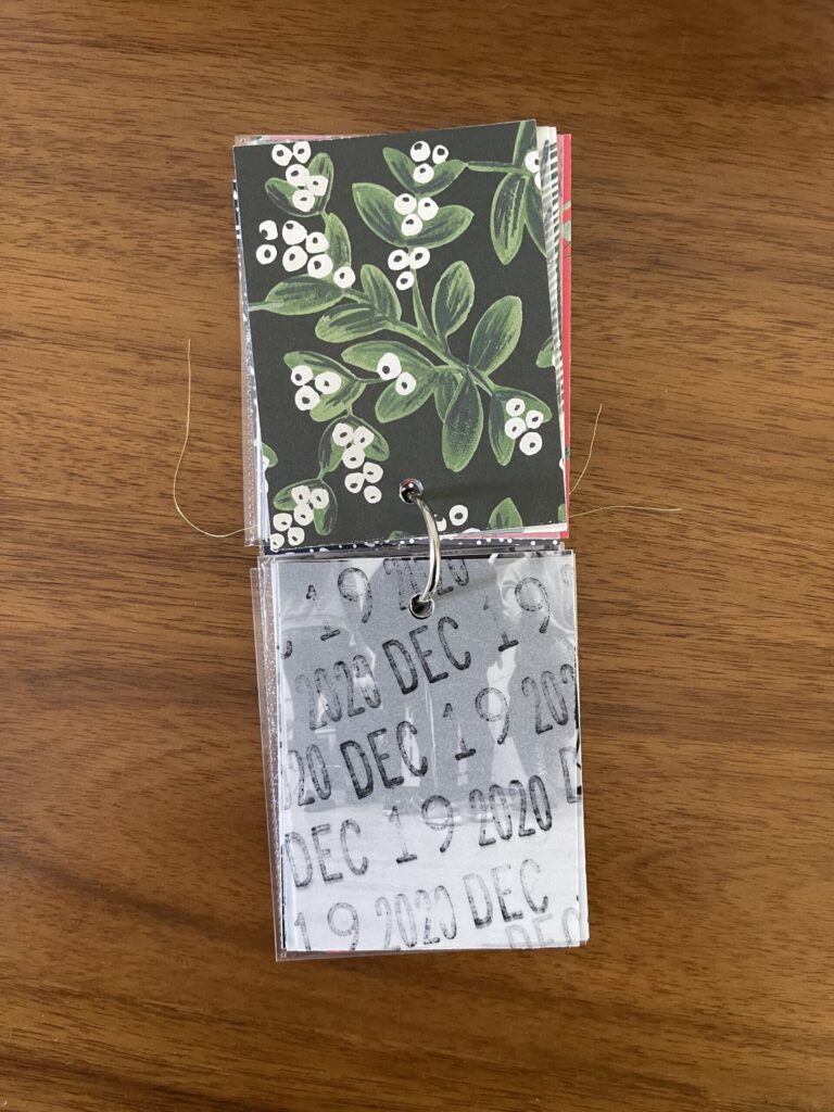 2020. The top page is a piece of patterned paper. The bottom page is a piece of vellum stamped repeatedly with the date. Beneath the vellum is a black-and-white photo from that year's visit. 