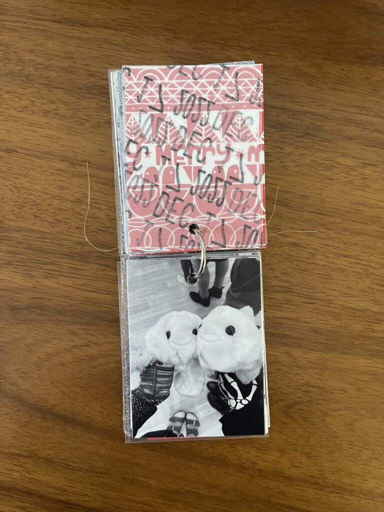 2022: the vellum page stamped with the date is flipped over to reveal a black-and-white photo of one of my kids and I holding our un-stuffed Build-A-Bear stuffed animals. 