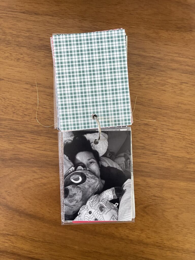 2023: the vellum page stamped with the date is flipped over to reveal a black-and-white photo of me hugging a stuffed animal in bed. 