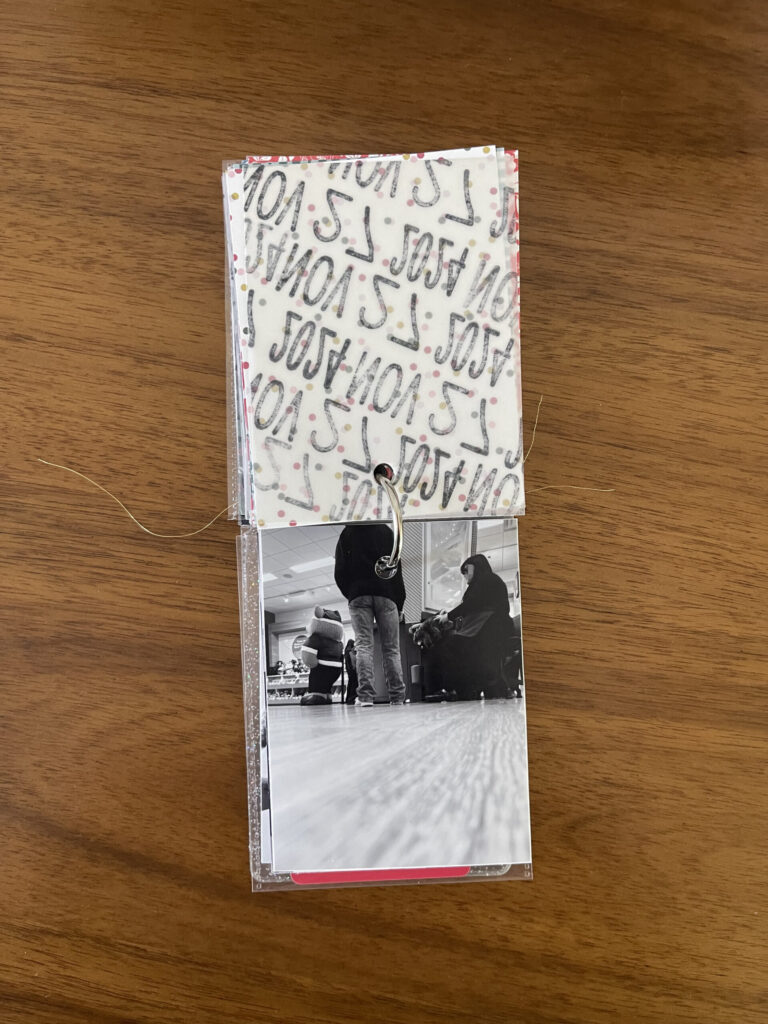 2024: the vellum page stamped with the date is flipped over to reveal a black-and-white photo of one of my kids from behind, stepping on the pedal that "helps" the Build-A-Bear employee fill the stuffed animal with stuffing. 