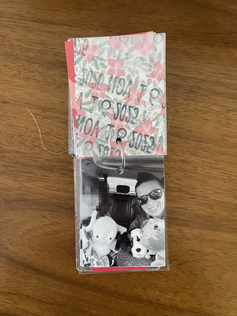 2025: the vellum page stamped with the date is flipped over to reveal and black-and-white photo of me and one of my kids posing with our Build-A-Bears in the car.