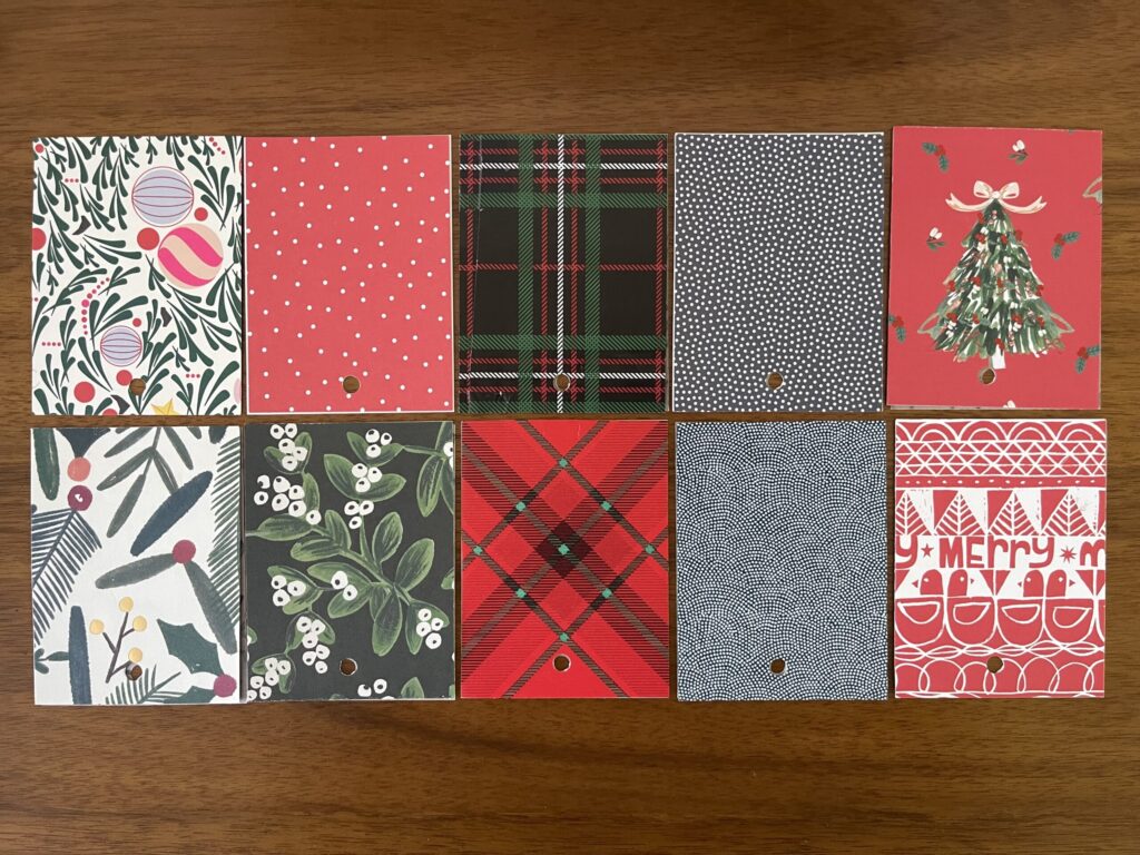 Various holiday-themed papers cut down to 3 inches by 4 inches and arranged in two rows. 