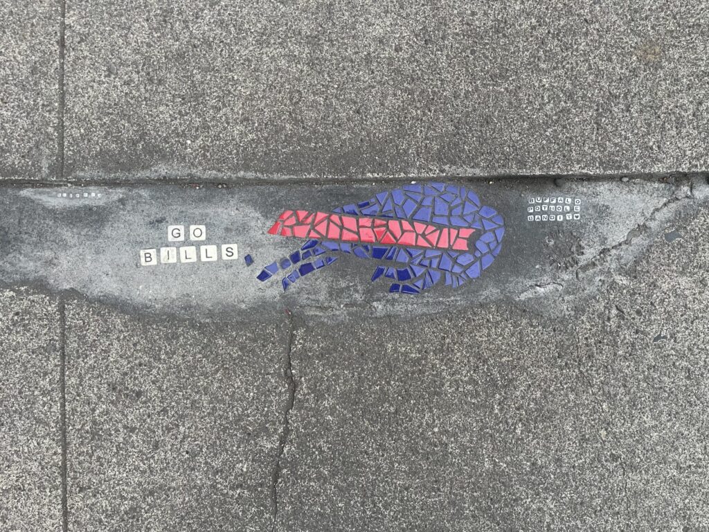 A mosaic Buffalo Bills logo with Scrabble letters that spell out "GO BILLS" and friendship bracelet beads that spell out "BUFFALO POTHOLE BANDIT"