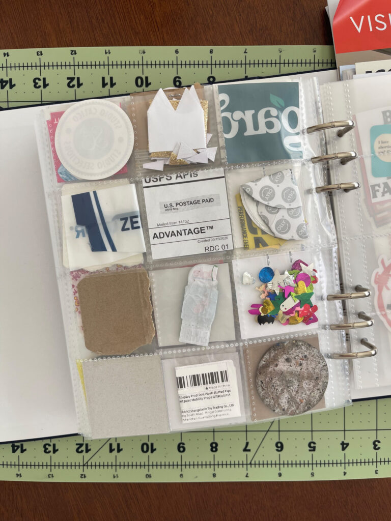 Back of a 6-inch by 8-inch page protector divided into 12 two-inch by two-inch pockets. Each pocket hold a piece of ephemera from my life in September 2026, as enumerated in the bulleted lists in the body of the post.